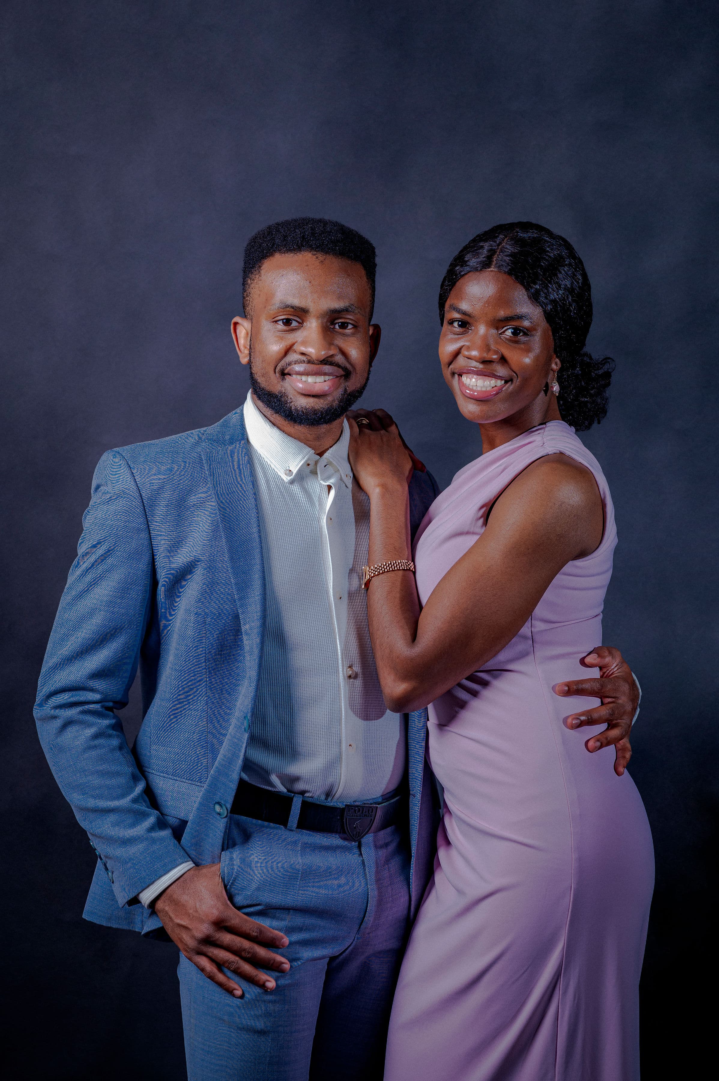 David in a blue suit and Esther in a lilac gown, smiling warmly at the camera