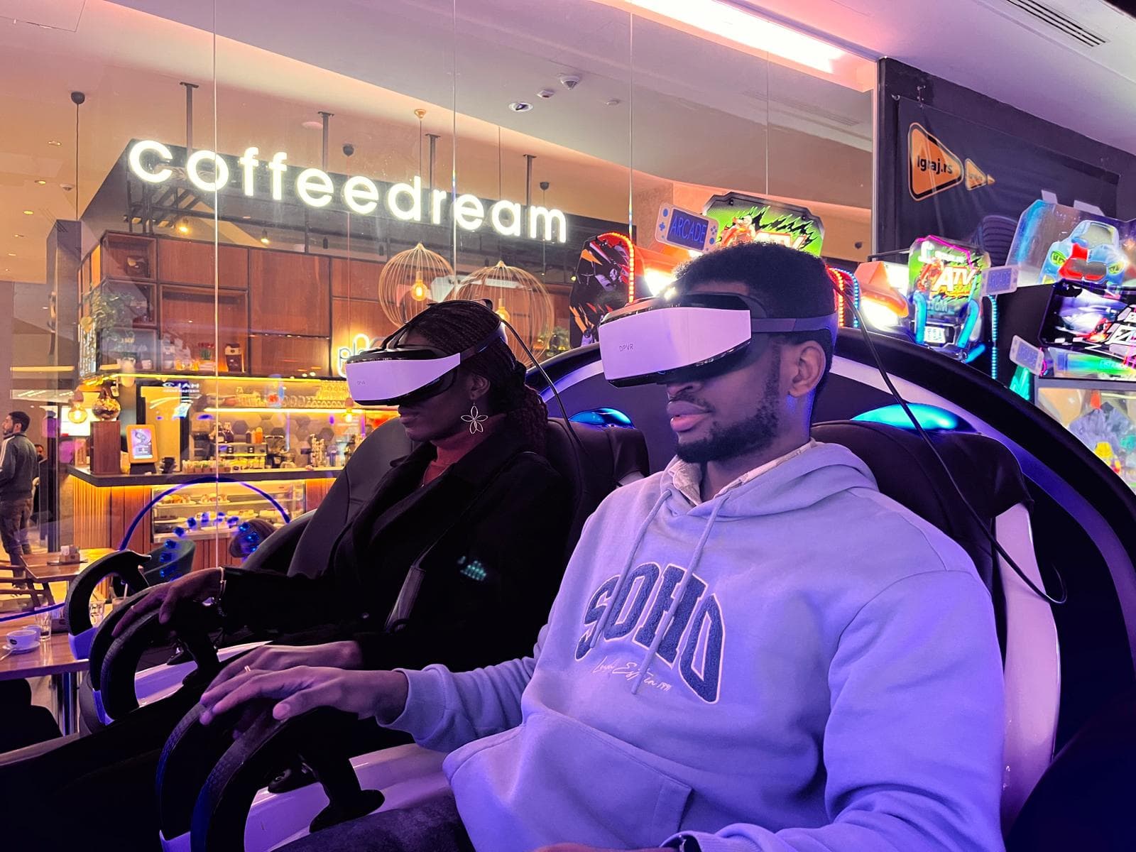 David and Esther wearing VR headsets at a cafe